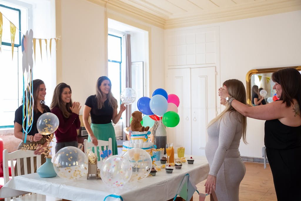 Women Standing in Front of Table With Balloons